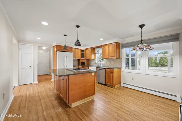 a kitchen with stainless steel appliances kitchen island wooden floors and granite counter tops