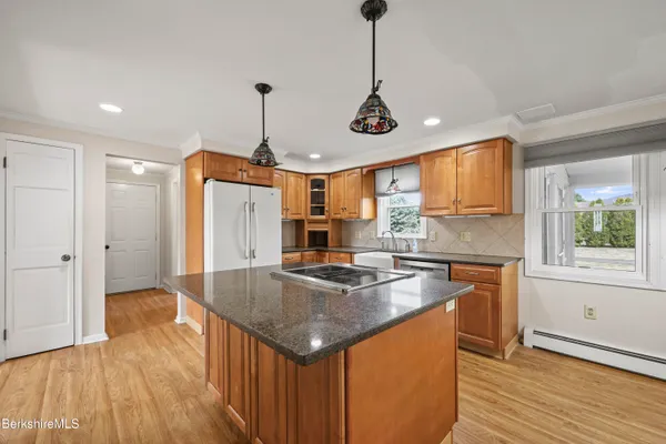 a kitchen with stainless steel appliances granite countertop a sink a stove and a wooden floors