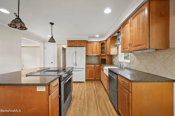 a kitchen with stainless steel appliances granite countertop a sink a stove and refrigerator