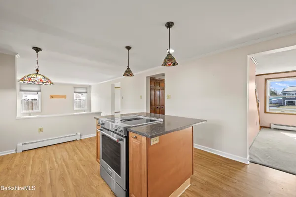 a kitchen with stainless steel appliances granite countertop a sink a stove and a wooden floors