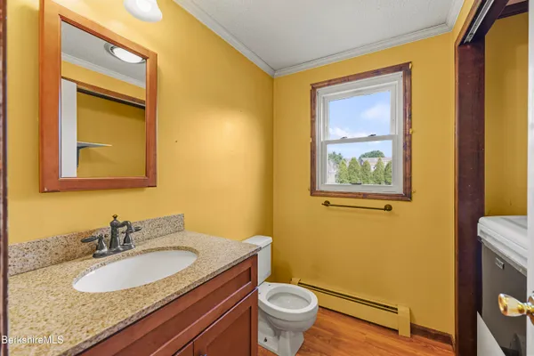 a bathroom with a granite countertop toilet sink and mirror