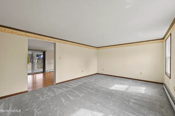 a view of an empty room with wooden floor and closet