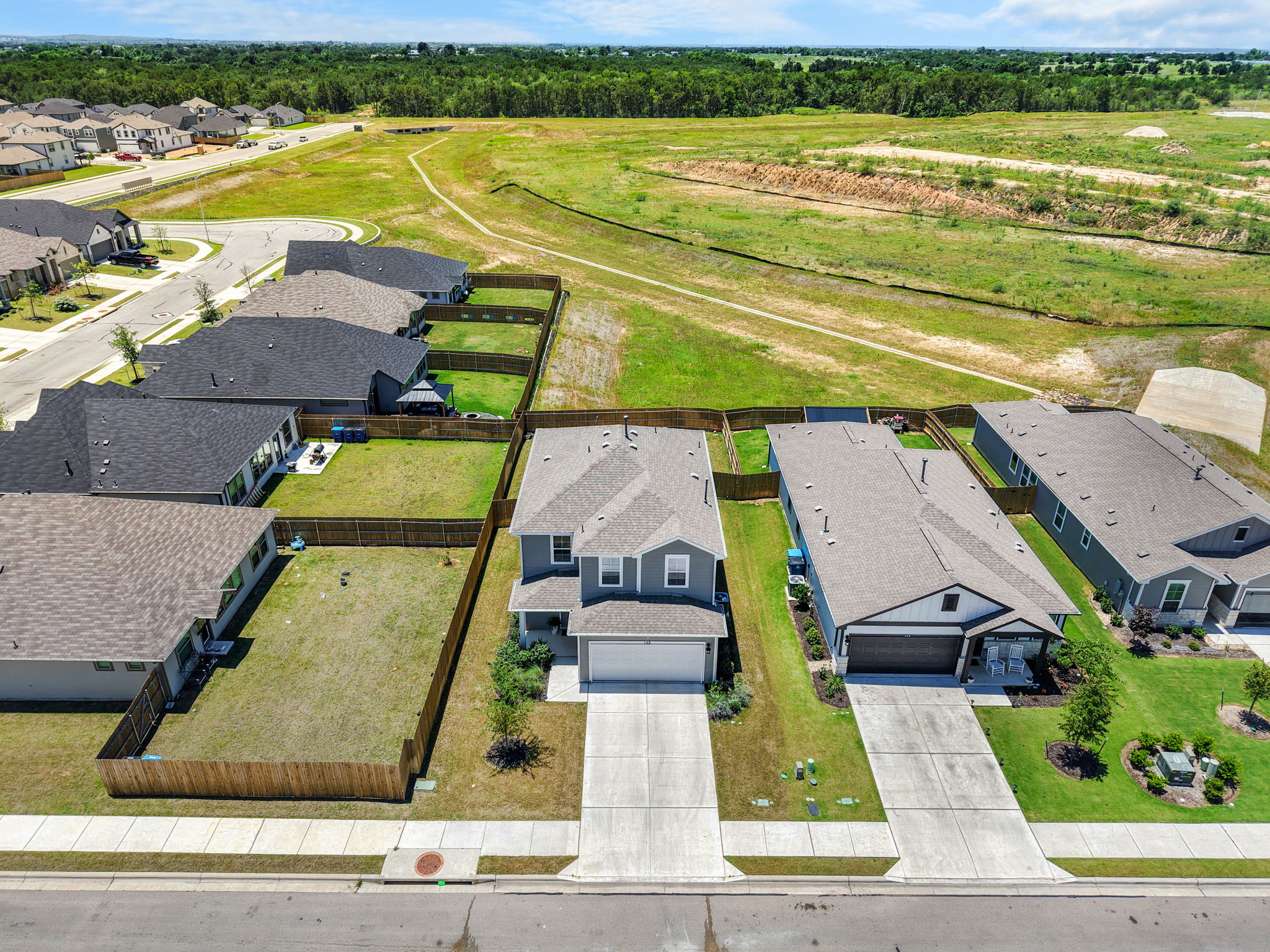 148 Hidalgo Lane Elgin, TX 78621 - Photo 4 of 38 Bird's eye view of a tranquil neighborhood with well-maintained homes and lush, expansive green spaces.