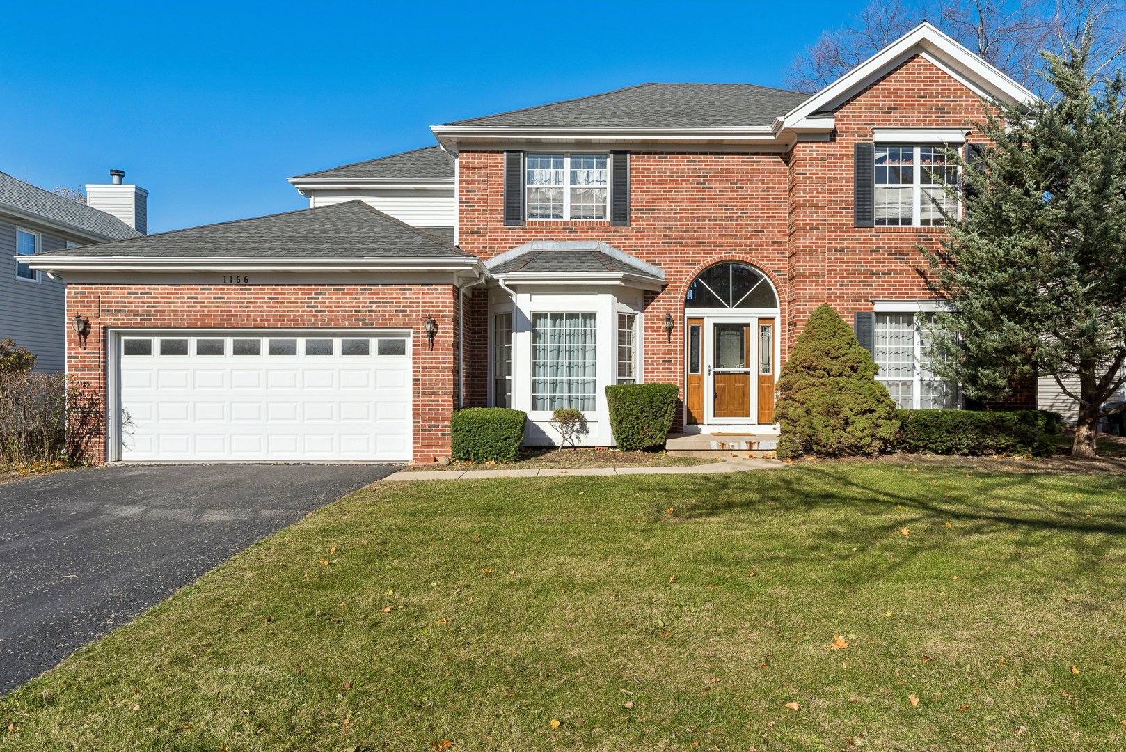 a front view of a house with a garden and garage