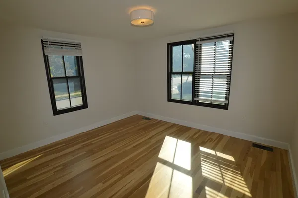 a view of a room that has a window and wooden floor