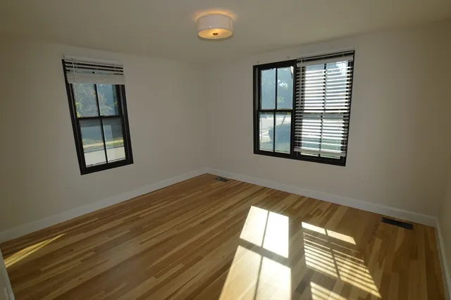 a view of a room that has a window and wooden floor
