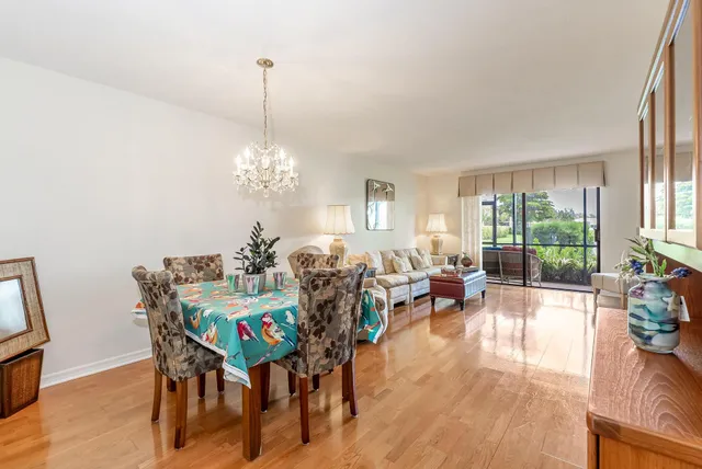 a view of a dining room with furniture a chandelier and wooden floor
