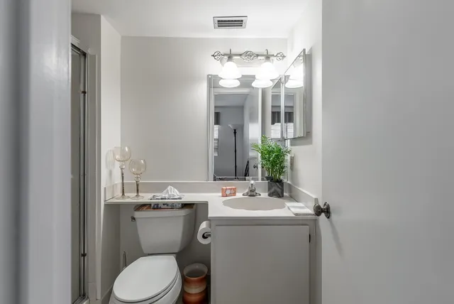 a bathroom with a toilet a sink and mirror