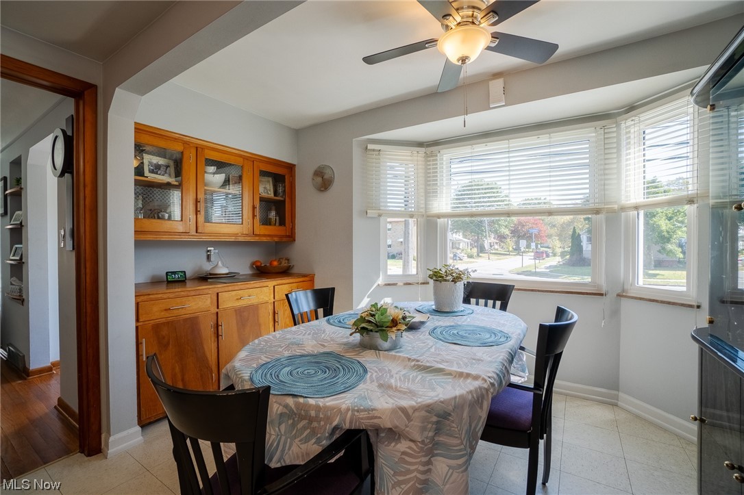 Hardwood floored dining area featuring ceiling fan