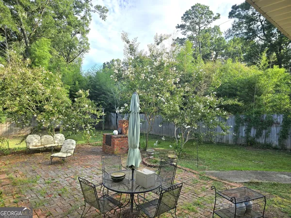 a view of a table and chairs in backyard of the house