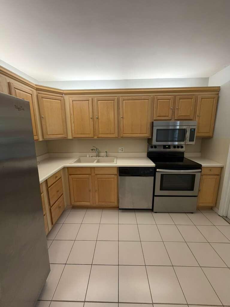 2601 South Course Drive, Unit 203 Pompano Beach, FL 33069 - Photo 12 of 33 a kitchen with a sink a stove and cabinets
