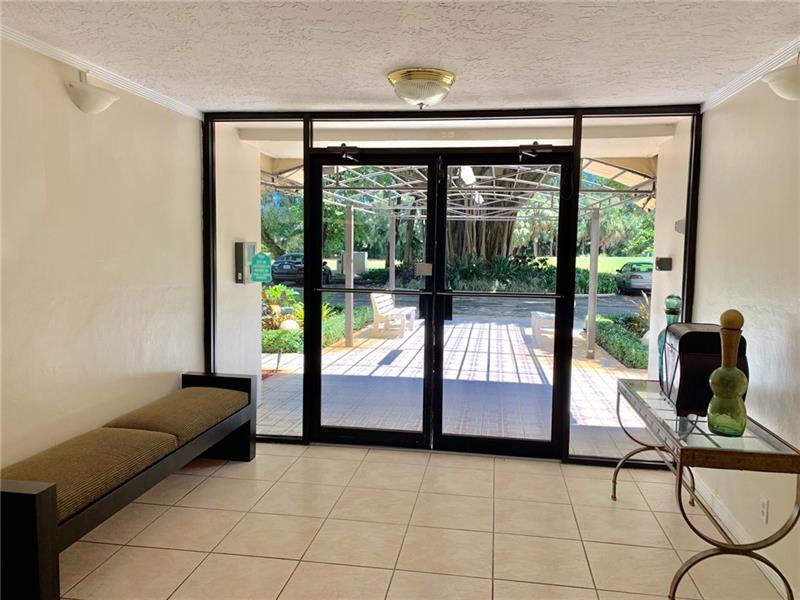 2601 South Course Drive, Unit 203 Pompano Beach, FL 33069 - Photo 4 of 33 a living room with a large window and furniture