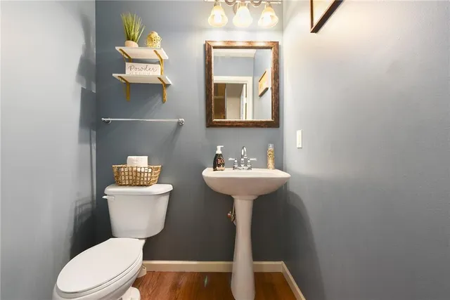 a bathroom with a toilet sink and mirror