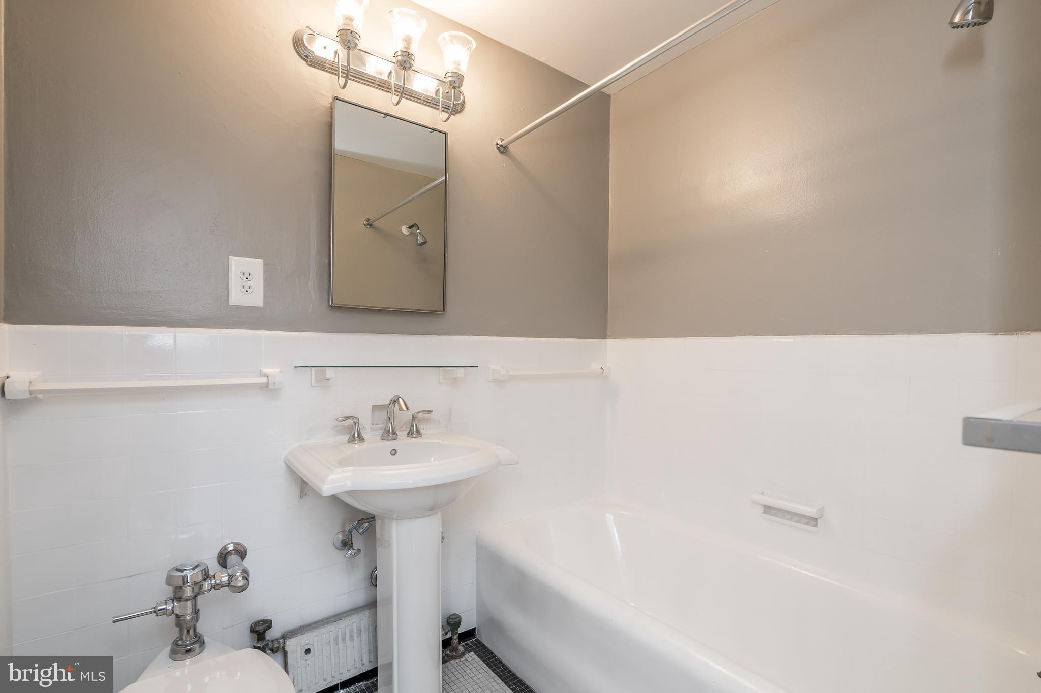 2031 Locust Street, Unit 602 Philadelphia, PA 19103 - Photo 13 of 24 a bathroom with a sink a bathtub and a mirror