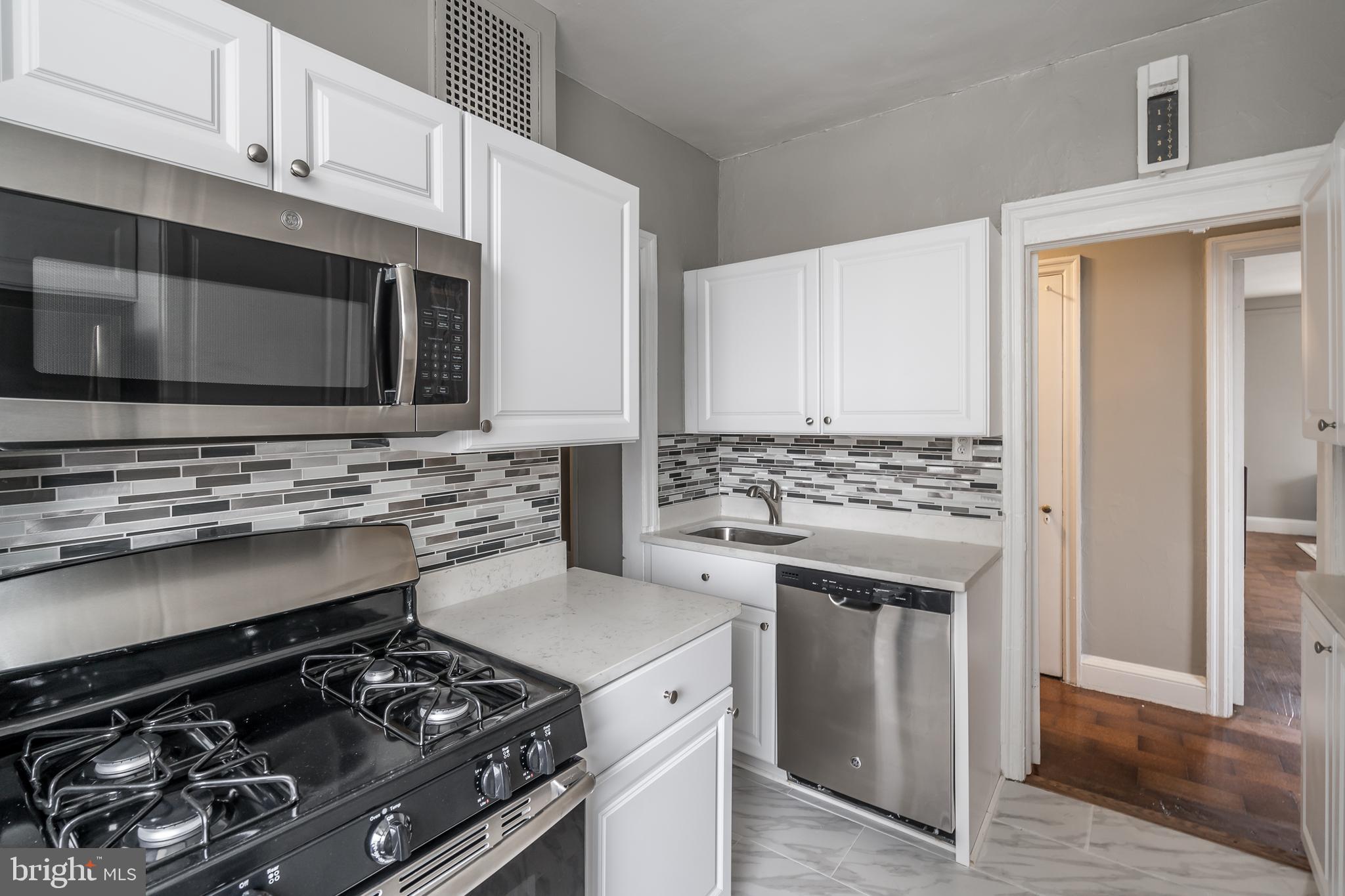 2031 Locust Street, Unit 602 Philadelphia, PA 19103 - Photo 5 of 24 a kitchen with stainless steel appliances granite countertop a stove and a microwave