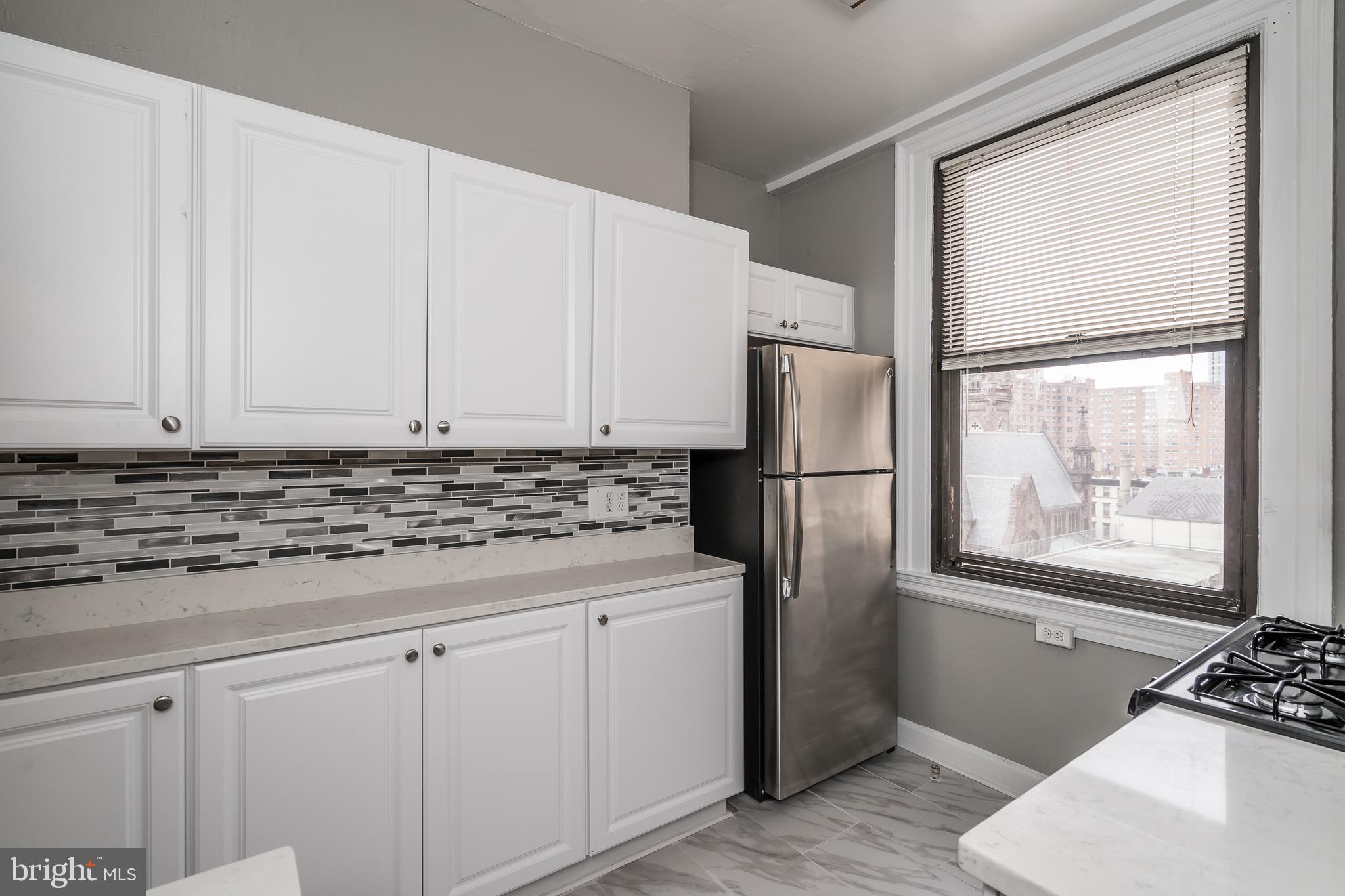 2031 Locust Street, Unit 602 Philadelphia, PA 19103 - Photo 6 of 24 a kitchen with stainless steel appliances granite countertop a refrigerator sink and cabinets