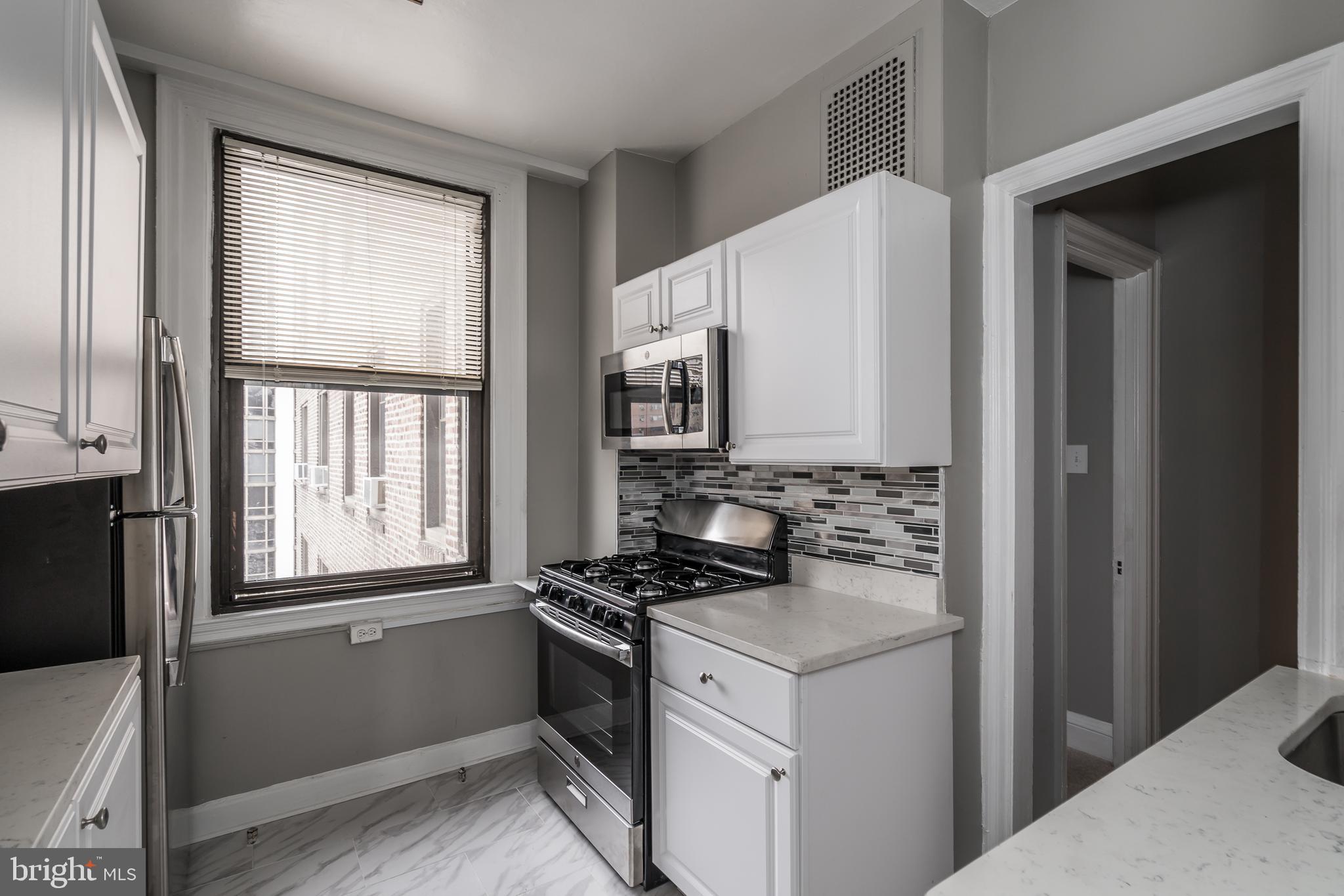 2031 Locust Street, Unit 602 Philadelphia, PA 19103 - Photo 7 of 24 a kitchen with a refrigerator and a stove top oven