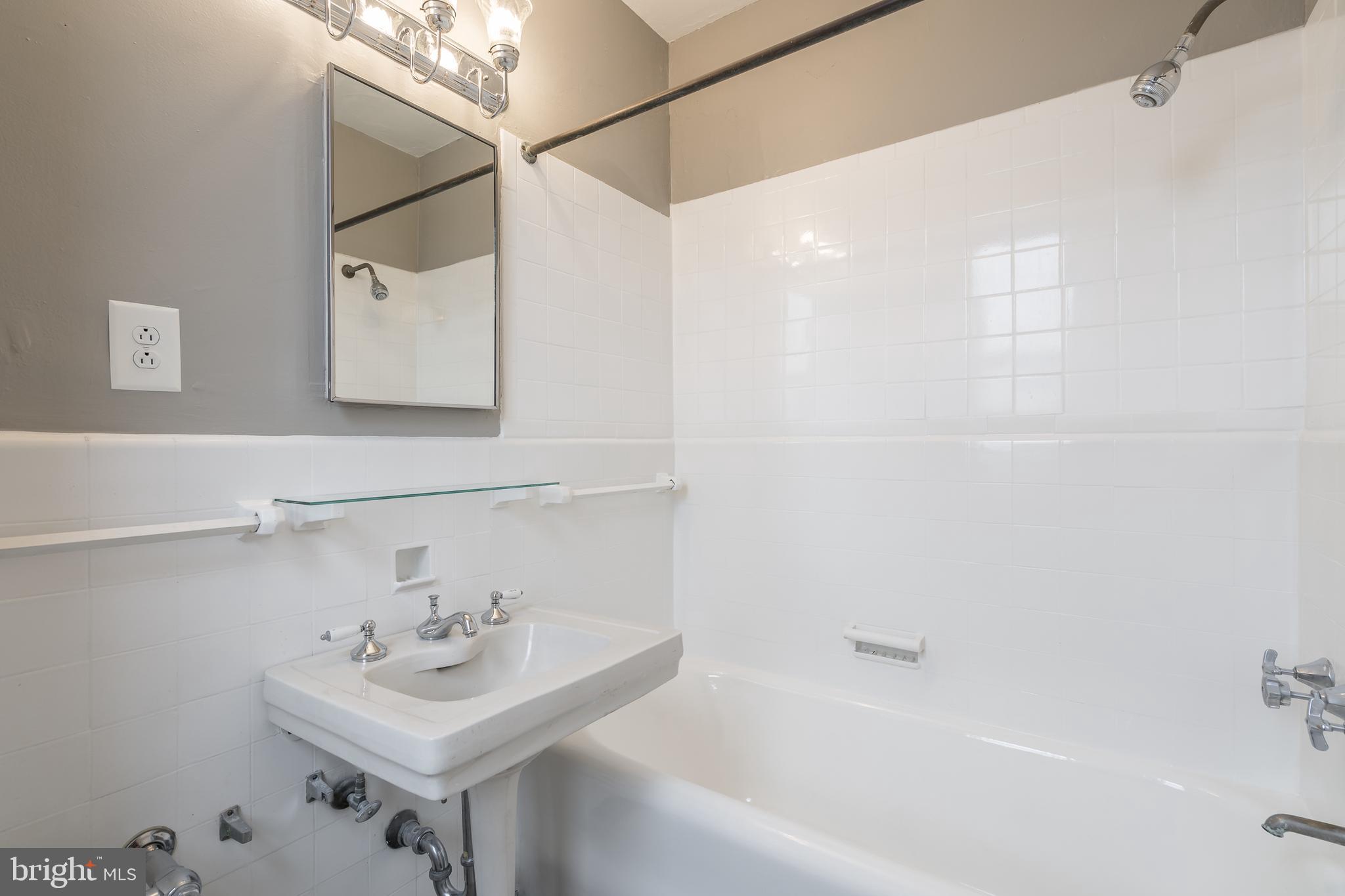 2031 Locust Street, Unit 602 Philadelphia, PA 19103 - Photo 10 of 24 a bathroom with a sink a mirror and a bathtub
