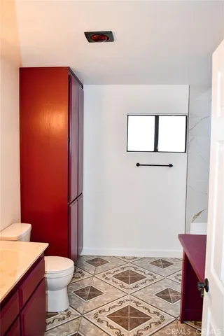 a bathroom with a toilet a sink and mirror