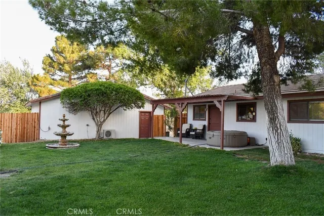a front view of a house with a garden and tree