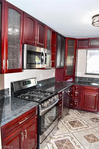 a kitchen with stainless steel appliances granite countertop a stove a sink and a microwave