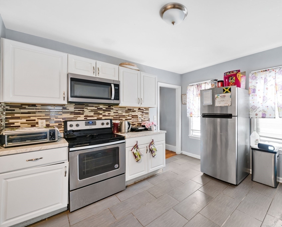 100-102 Wait Street Springfield, MA 01104 - Photo 13 of 35 a kitchen with stainless steel appliances kitchen island granite countertop a refrigerator stove and sink