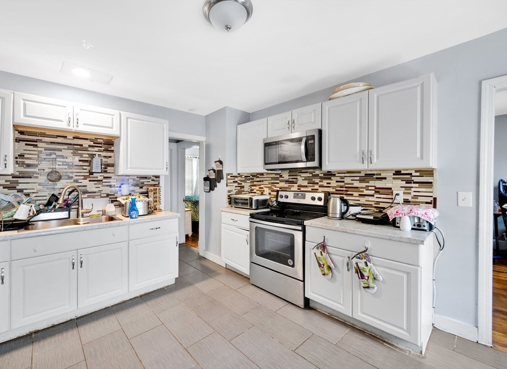 100-102 Wait Street Springfield, MA 01104 - Photo 14 of 35 a kitchen with white cabinets and appliances