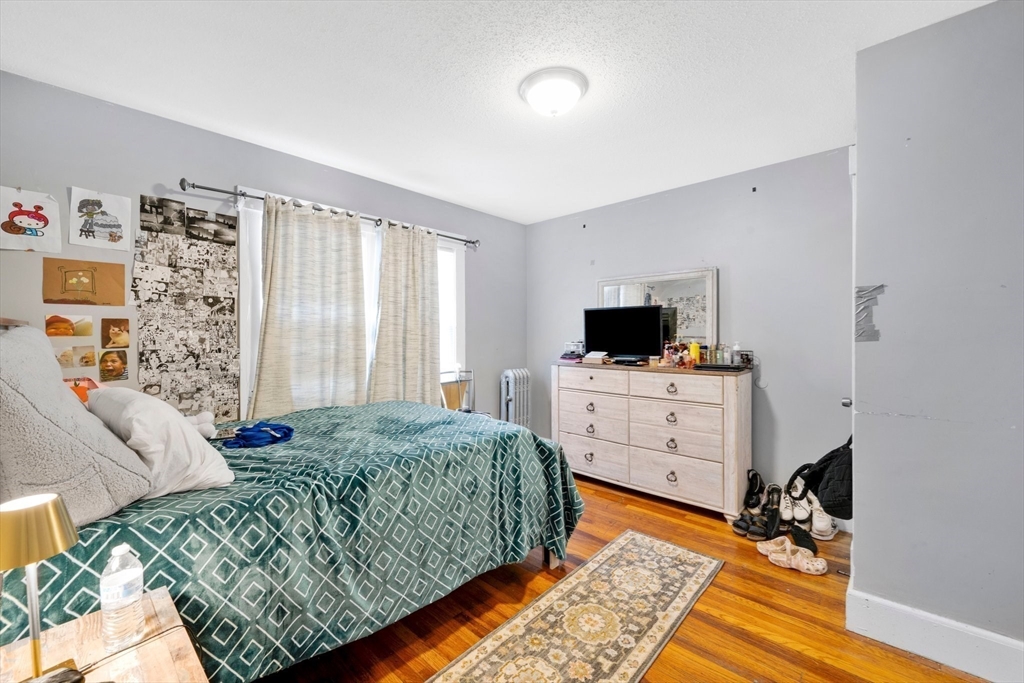 100-102 Wait Street Springfield, MA 01104 - Photo 22 of 35 a living room with a bed furniture flat screen tv and a window