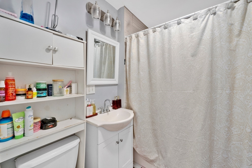 100-102 Wait Street Springfield, MA 01104 - Photo 24 of 35 a bathroom with a sink a toilet and shower curtain