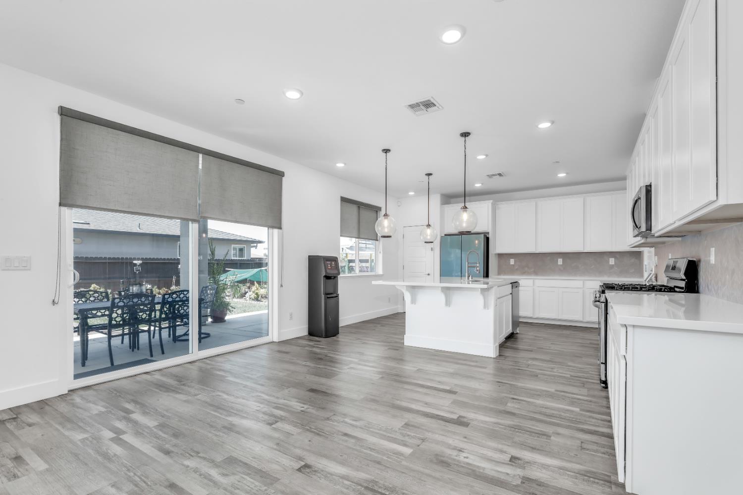 650 Nathaniel Avenue Galt, CA 95632 - Photo 11 of 46 a kitchen with stainless steel appliances kitchen island wooden floors wooden cabinets and dining table