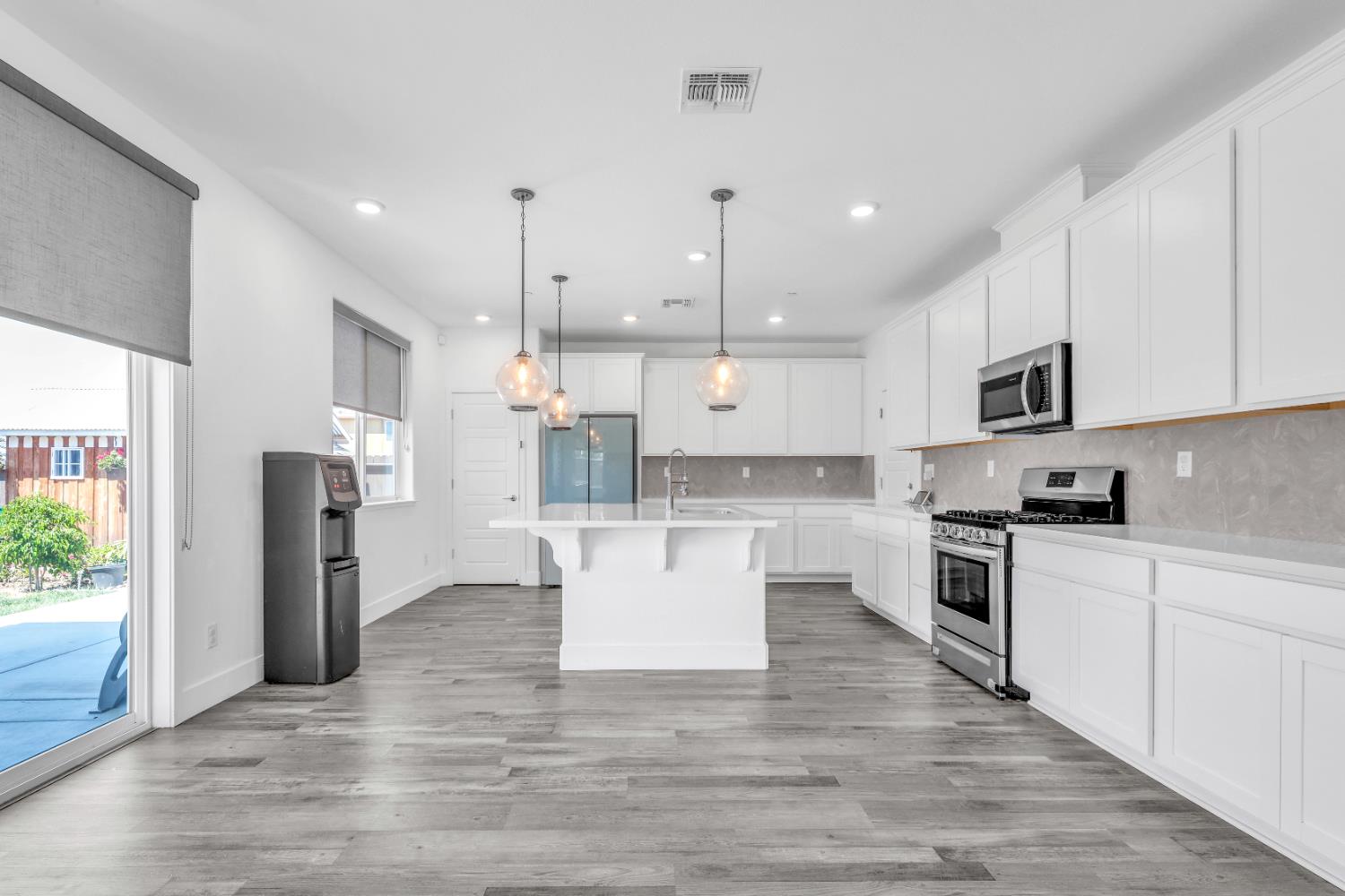 650 Nathaniel Avenue Galt, CA 95632 - Photo 12 of 46 a large kitchen with white cabinets stainless steel appliances and wooden floor