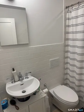 a bathroom with a sink a toilet and mirror