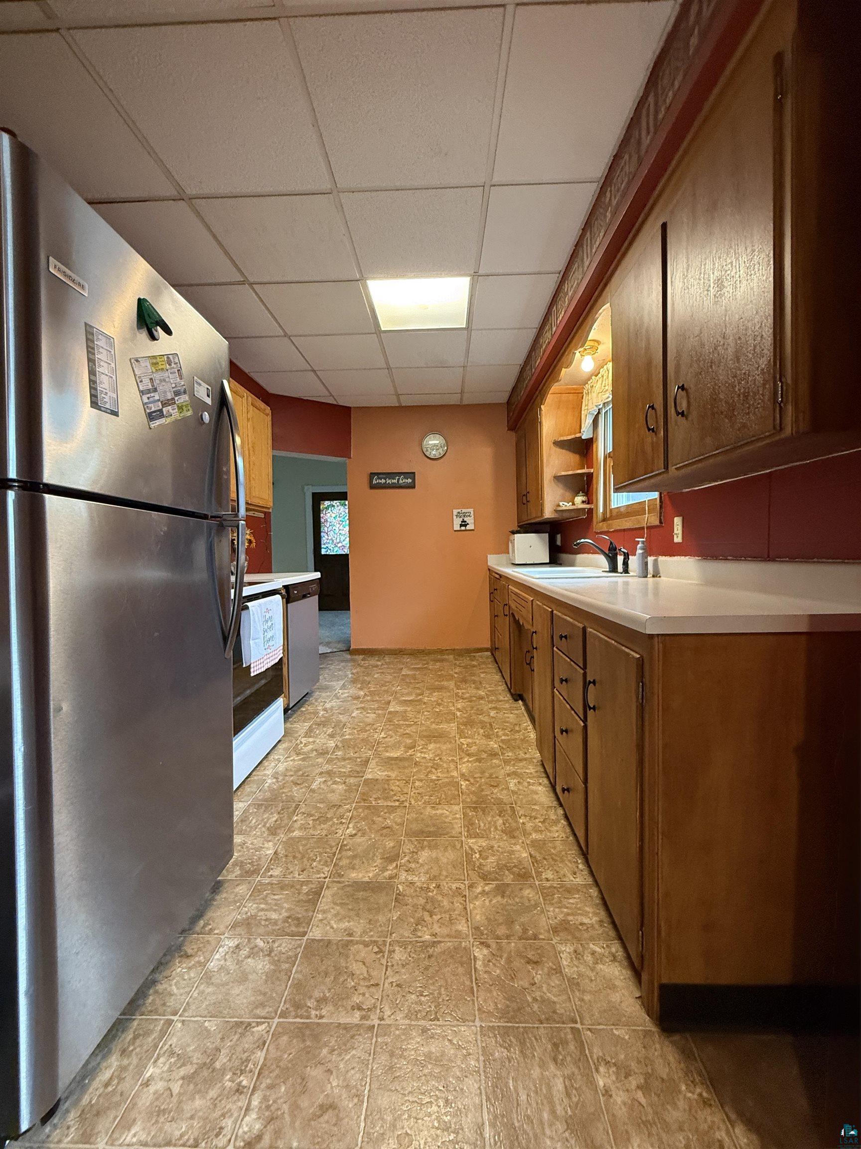 809 16th Street North Virginia, MN 55792 - Photo 21 of 44 Kitchen featuring appliances with stainless steel finishes, a paneled ceiling, open shelves, and light countertops