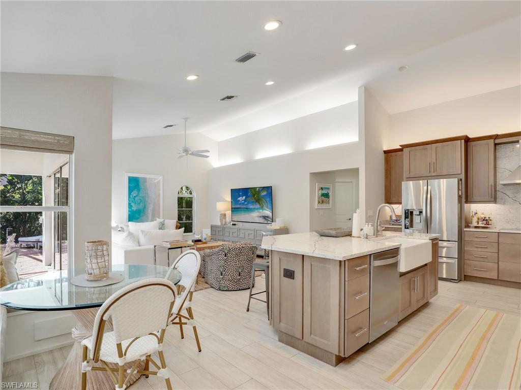 471 Ibis Way Naples, FL 34110 - Photo 14 of 40 a open kitchen with stainless steel appliances granite countertop a table chairs and a refrigerator