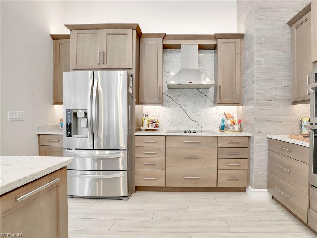 471 Ibis Way Naples, FL 34110 - Photo 15 of 40 a kitchen with white cabinets and stainless steel appliances