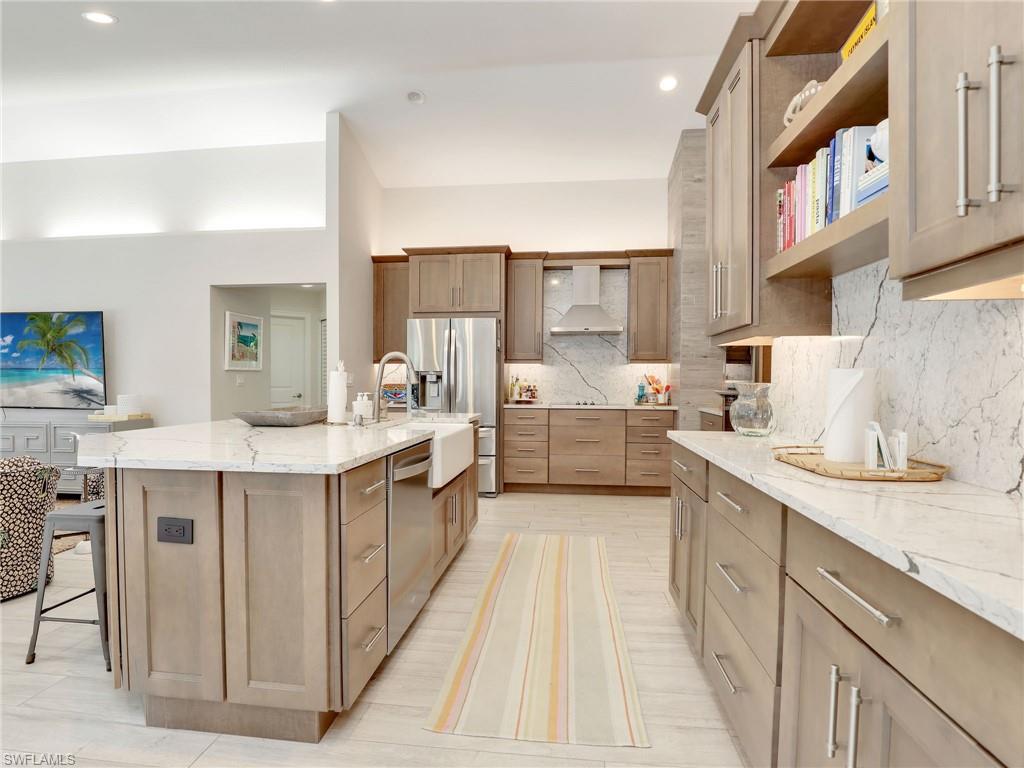 471 Ibis Way Naples, FL 34110 - Photo 16 of 40 a kitchen with stainless steel appliances kitchen island granite countertop a sink and cabinets