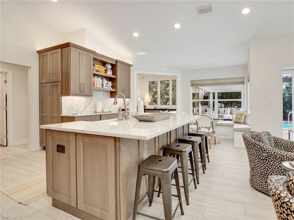 471 Ibis Way Naples, FL 34110 - Photo 17 of 40 a dining hall with stainless steel appliances kitchen island granite countertop a dining table and chairs