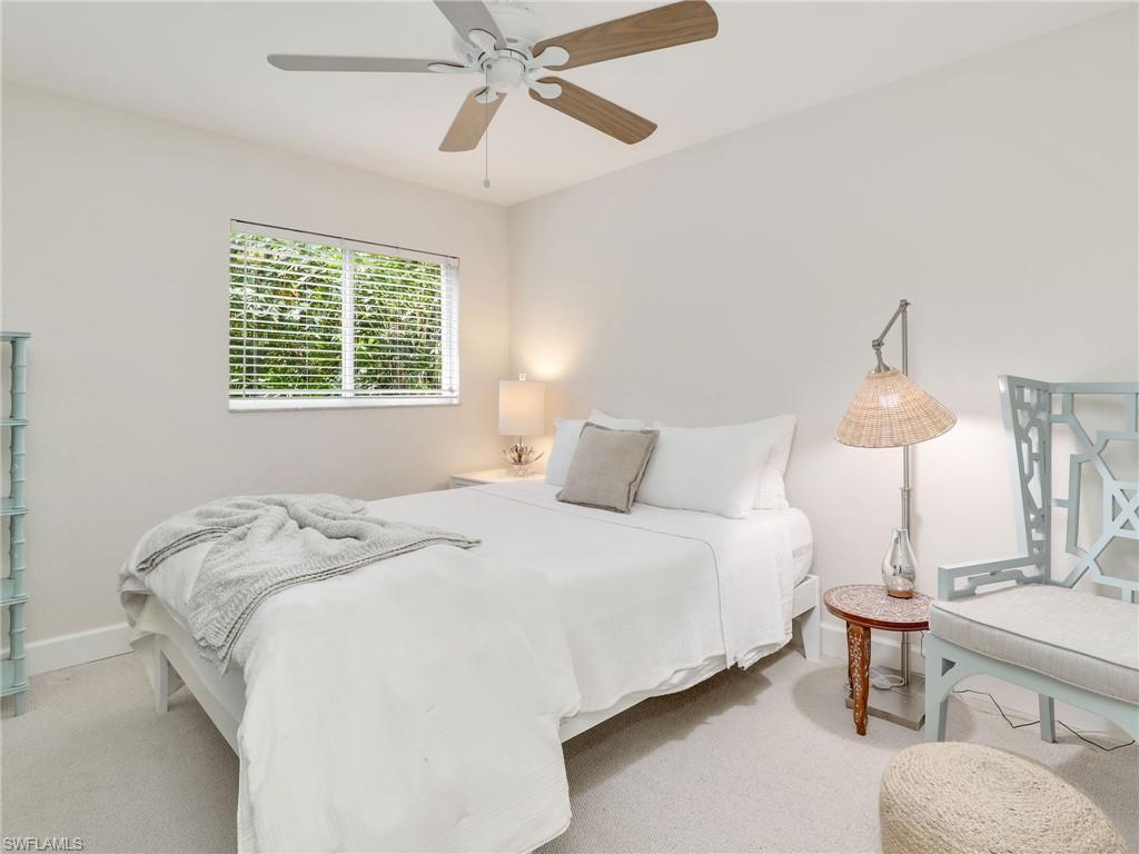 471 Ibis Way Naples, FL 34110 - Photo 30 of 40 a bedroom with a bed and a chandelier