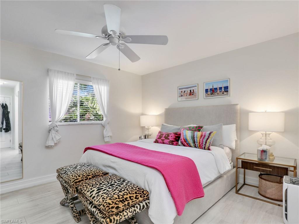471 Ibis Way Naples, FL 34110 - Photo 33 of 40 a bedroom with a bed and a chandelier