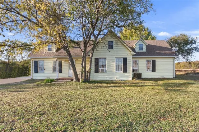 a white house that has a tree in front of it
