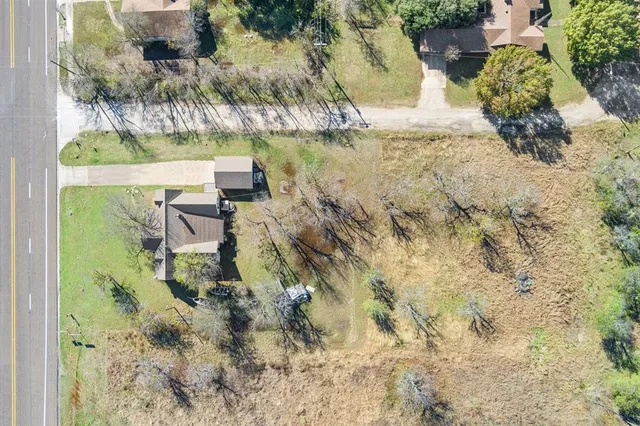 an aerial view of a house with a yard and large trees