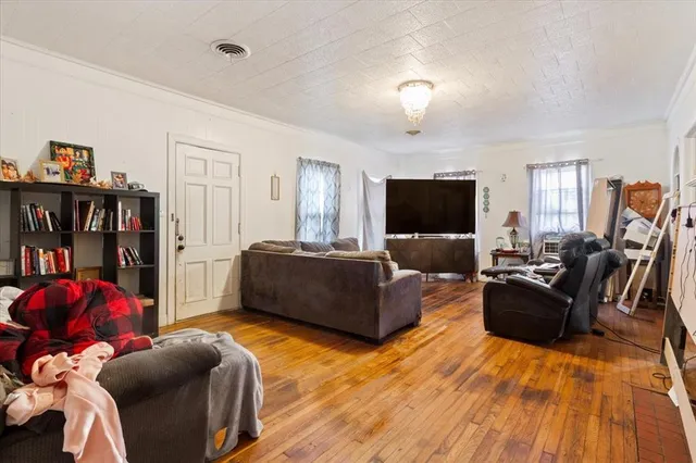 a living room with furniture a flat screen tv and a window
