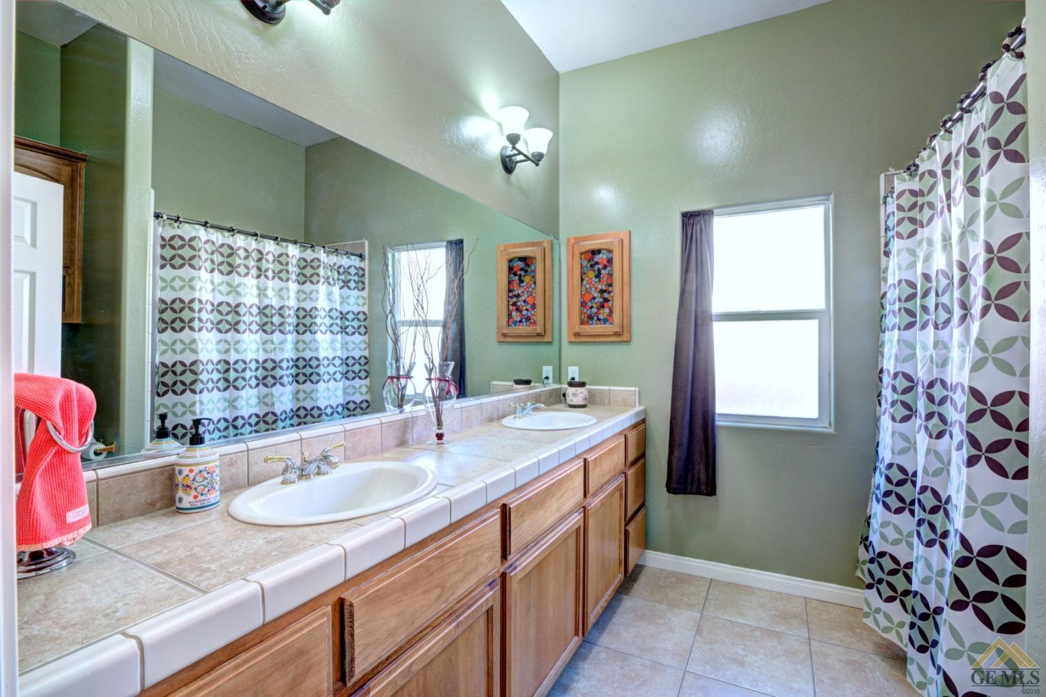 Undisclosed Address Shafter, CA 93263 - Photo 14 of 21 a spacious bathroom with a granite countertop sink a large mirror and a bathtub