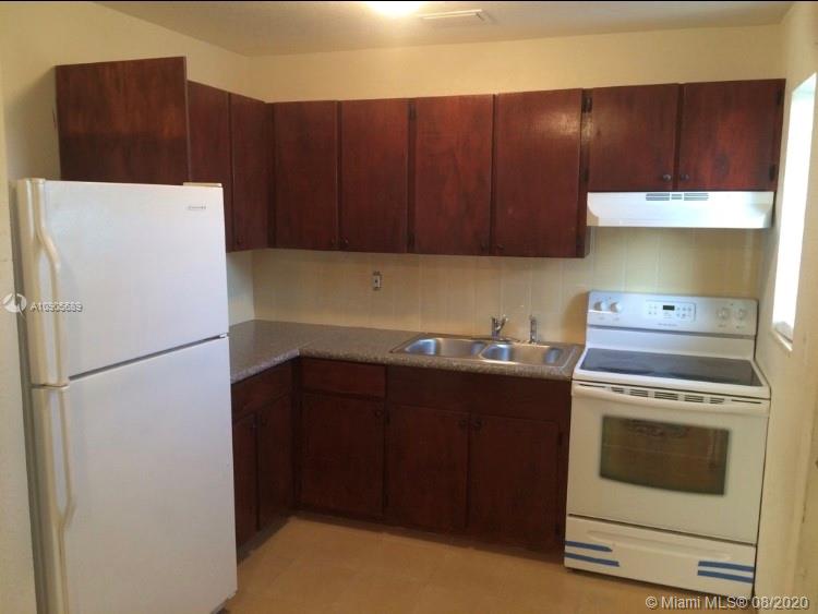 1131 West 4th Street Riviera Beach, FL 33404 - Photo 4 of 7 a kitchen with a refrigerator stove and cabinets