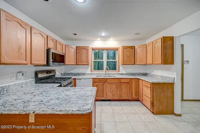 a kitchen with stainless steel appliances granite countertop wooden cabinets a sink and dishwasher