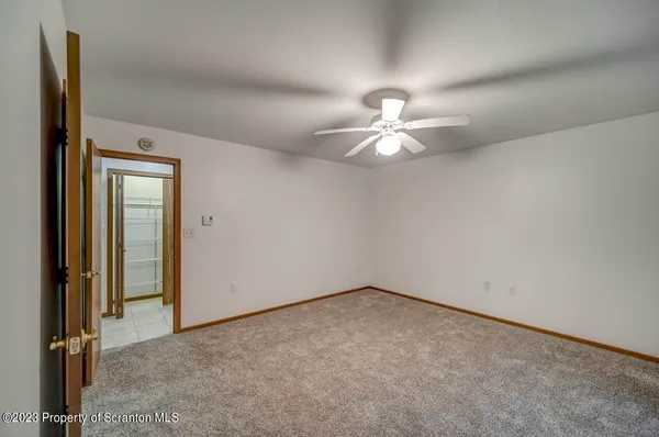 an empty room with chandelier fan