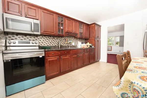 a kitchen with stainless steel appliances granite countertop a stove microwave and cabinets