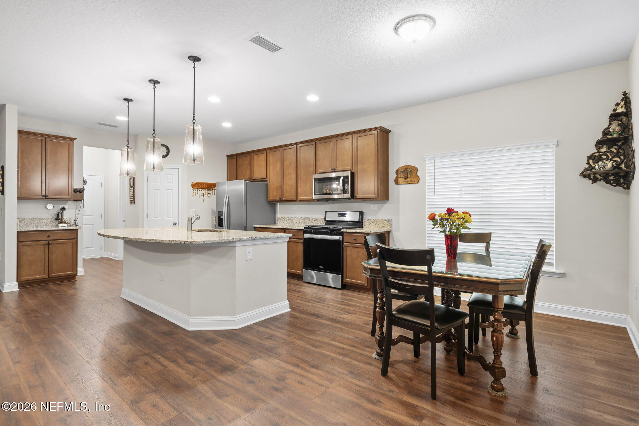 620 Ivory Palm Road Orange Park, FL 32073 - Photo 9 of 53 a kitchen with kitchen island granite countertop wooden floors white cabinets and appliances