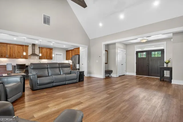 a kitchen with stainless steel appliances kitchen island granite countertop a table chairs refrigerator and microwave