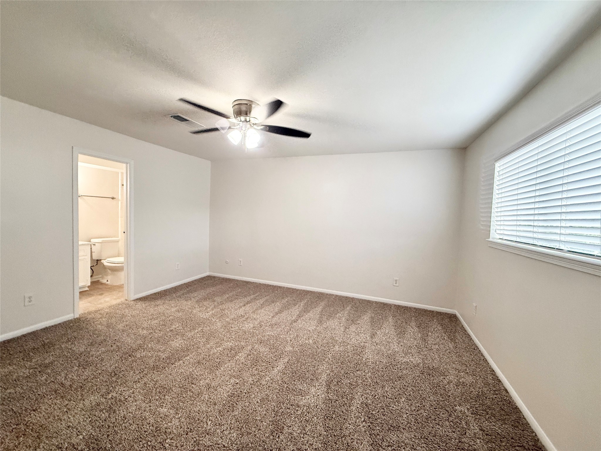 1497 Springrock Lane Houston, TX 77055 - Photo 14 of 23 an empty room with windows and fan